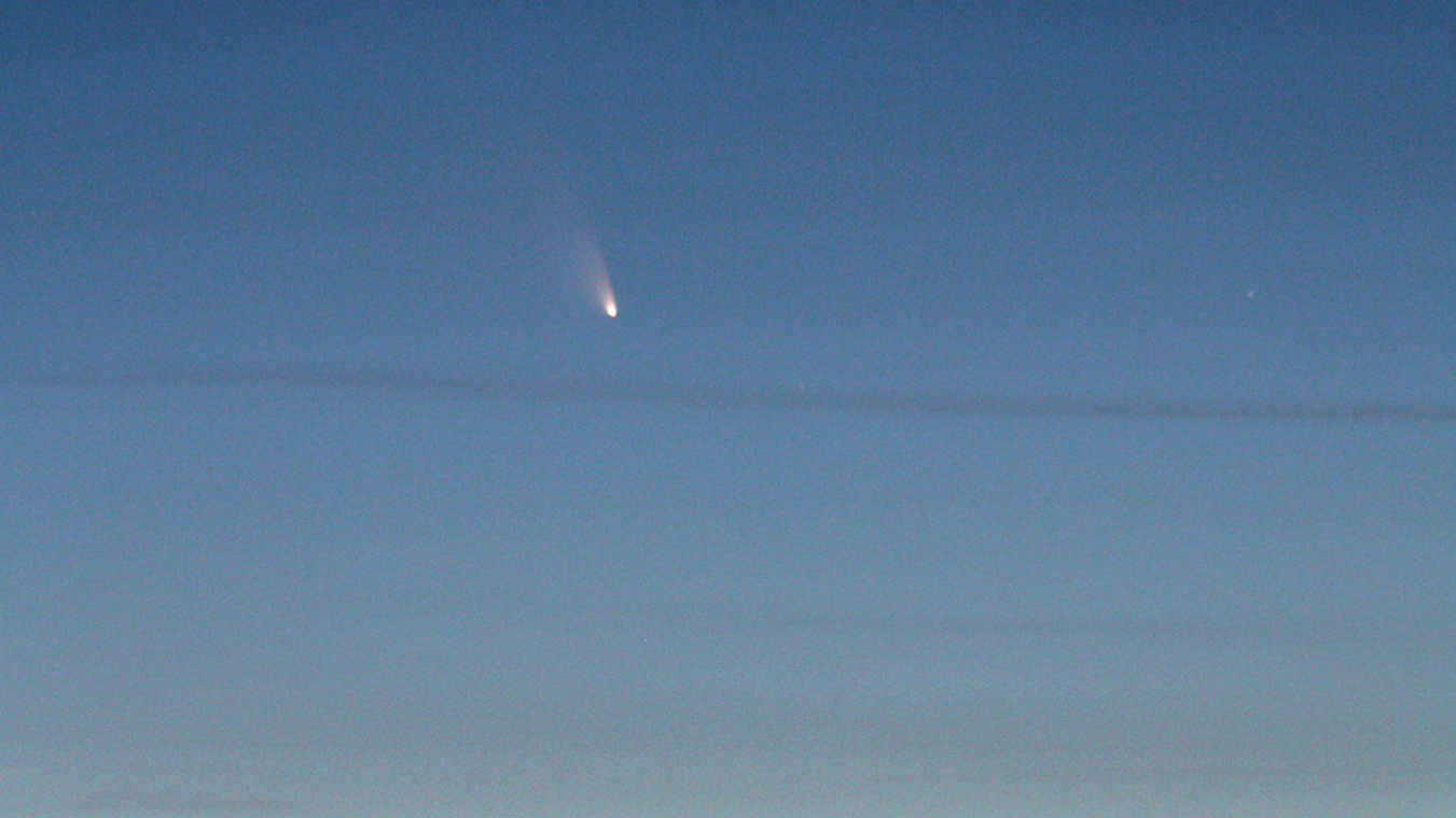 Cometa C/2011 L4 (PanSTARRS) ao anoitecer sobre a Floresta Negra. A imagem foi captada a 15.3.2013, logo após o pôr-do-sol, com uma teleobjetiva e uma distância focal de 300 mm, numa DSLR do tipo Canon D550. U. Dittler